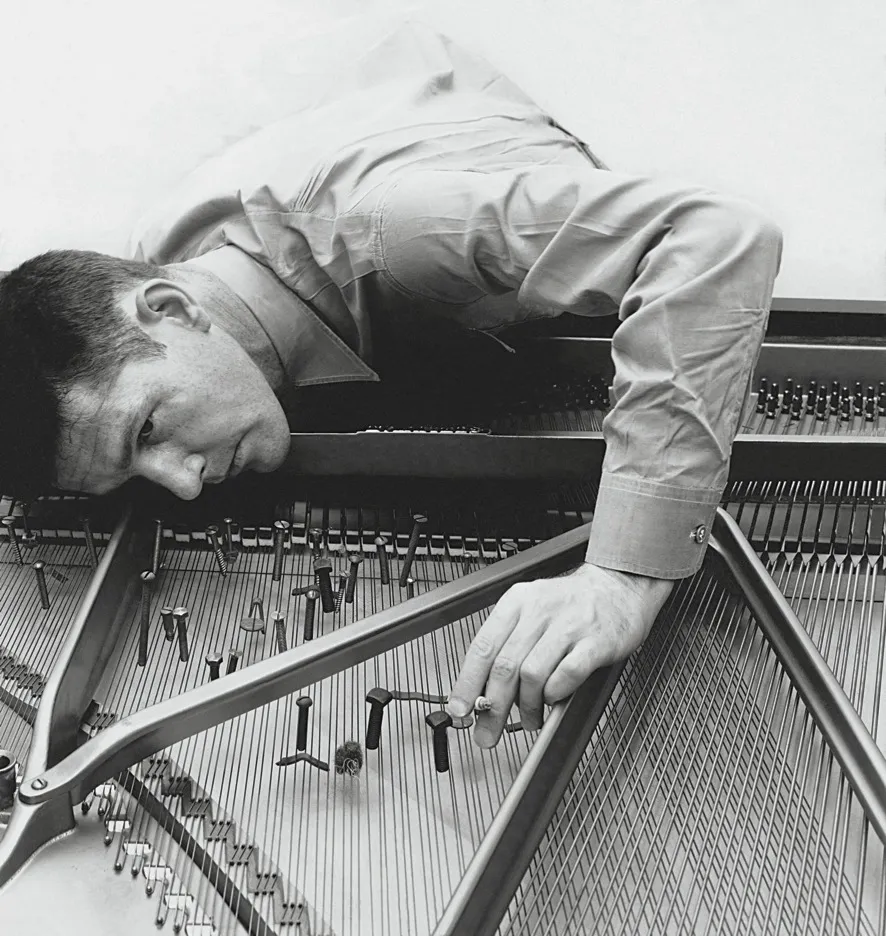 Cage preparing a piano, in 1947. Photograph by Irving Penn.